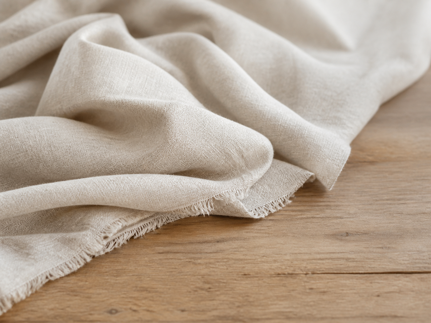 Folded linen on a warm wood surface