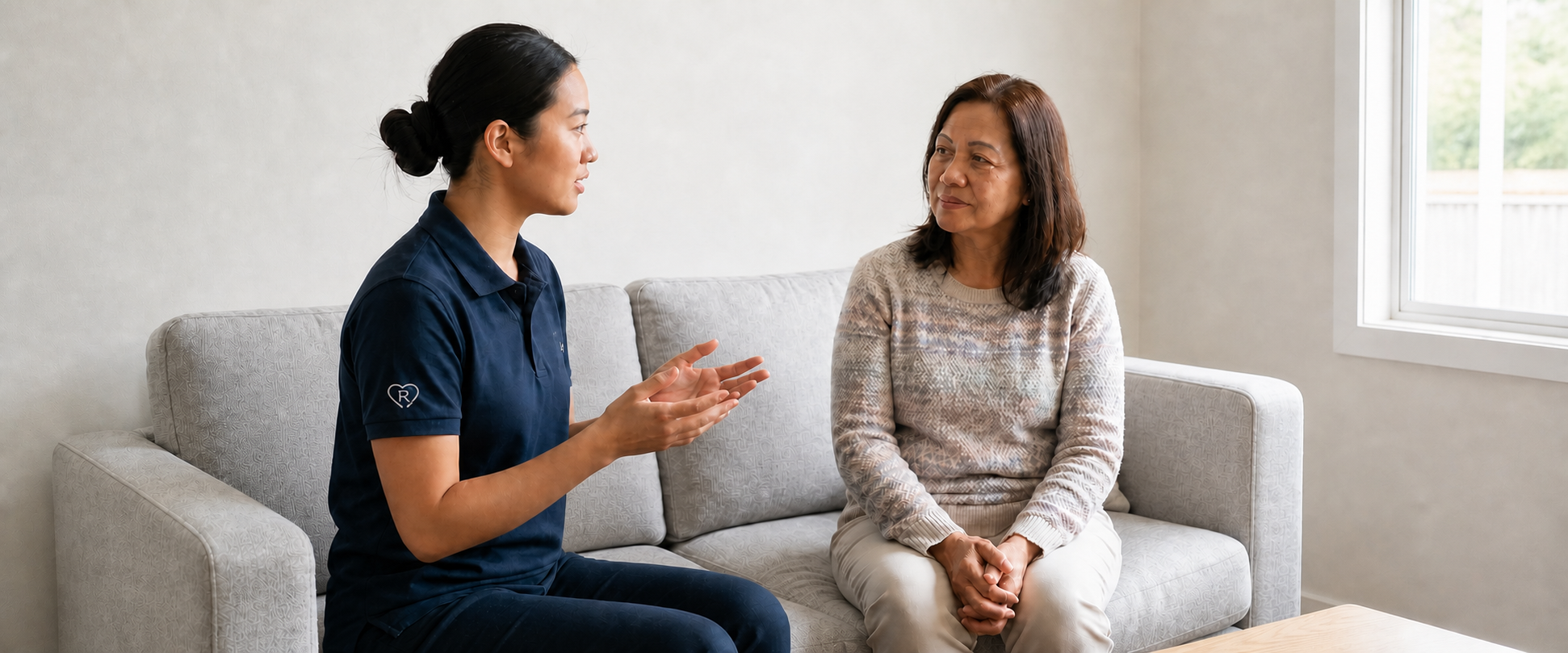 Respiratory therapist with the Respyre heart-and-R logo on her sleeve explaining something to a client at home